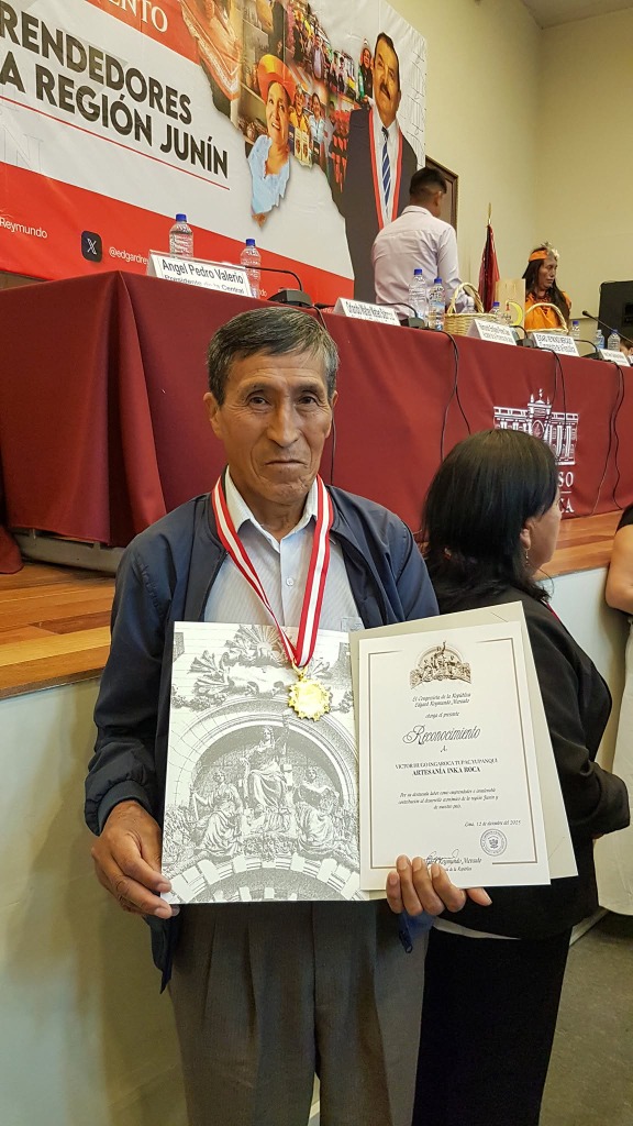 Victor Hugo Ingaroca con diploma y medalla de reconocimiento